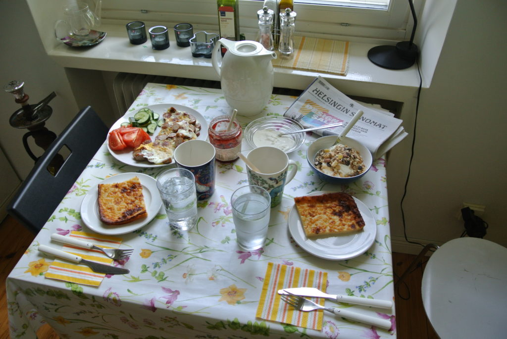 Breakfast with coffee, pancakes, omelette, yogurt and berries.