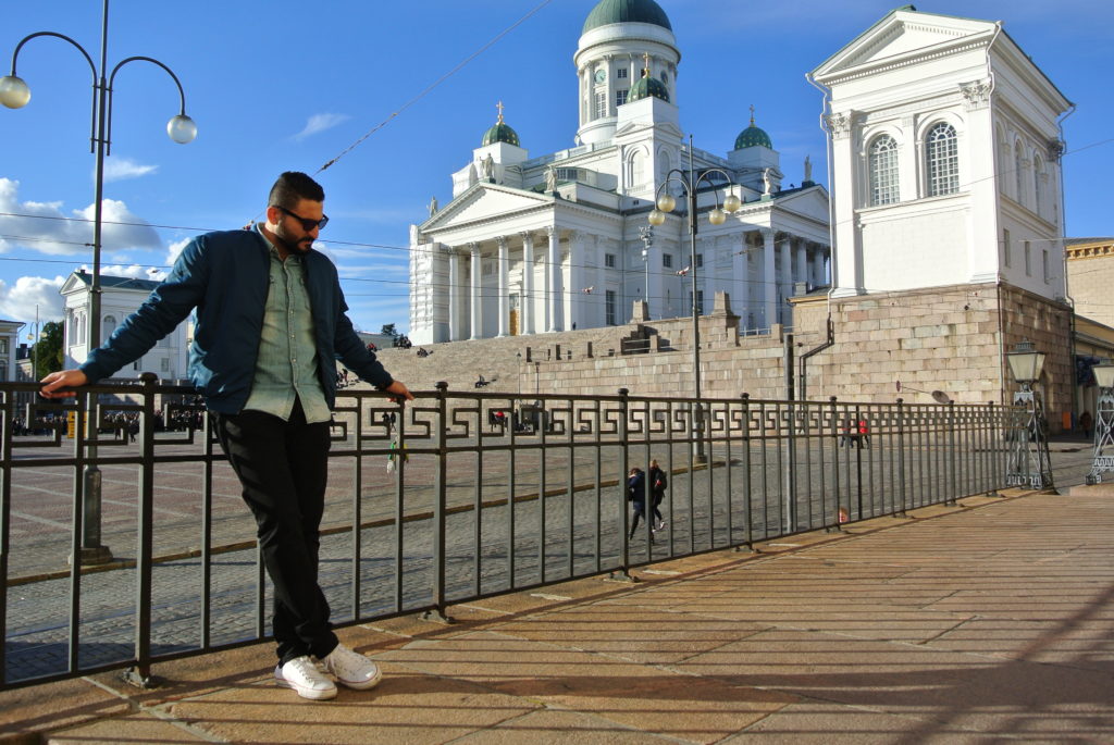 Beautiful Helsinki A handsome Arabic man standing in front of the Beautiful Helsinki Senate Square church in the sunshine against blue sky