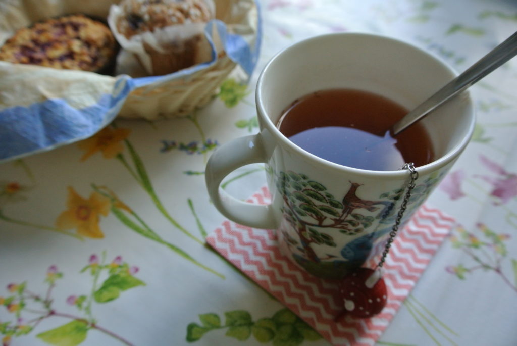 Day off A cup of tea and muffins on a colorful table cloth