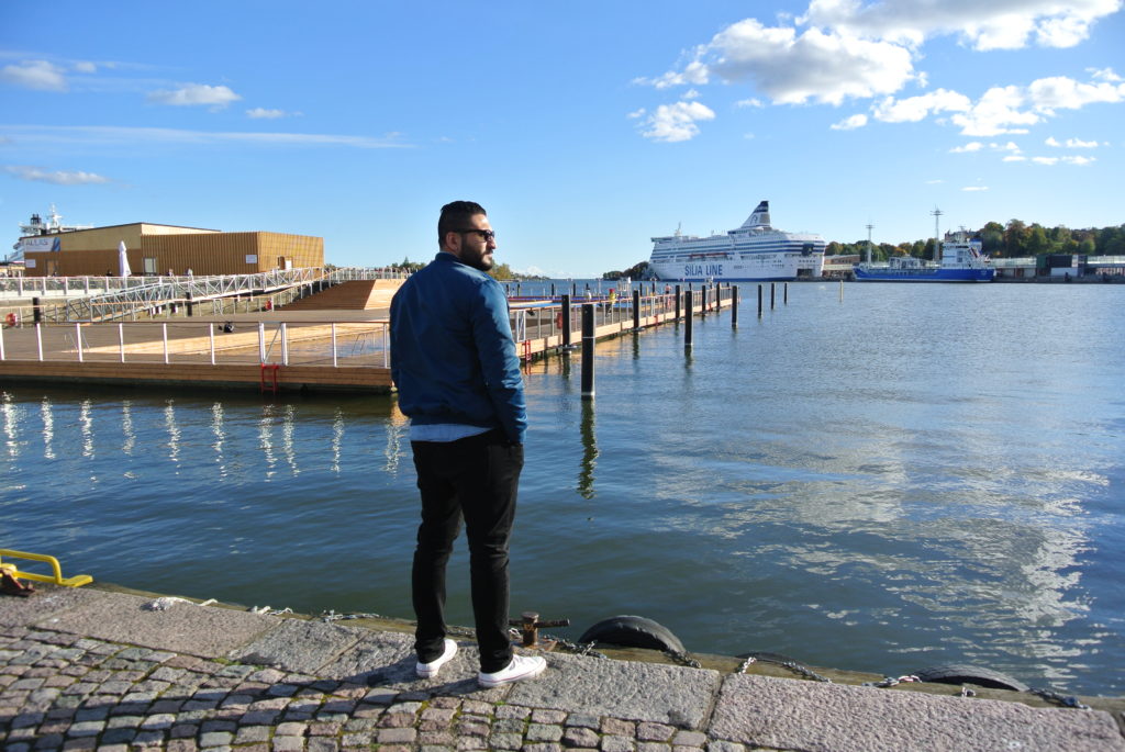 Fish market a handsome Arabic man standing by the water in Helsinki