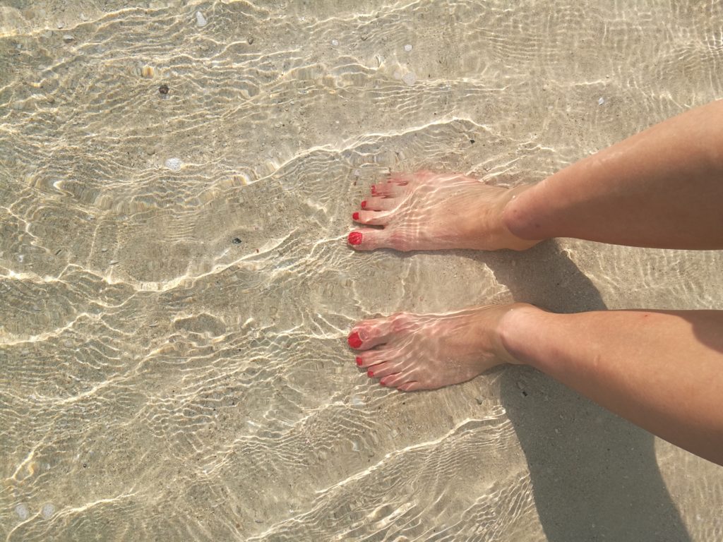 Layover in Dubai Palm Jumeirah beach clear water white sand happy feet in the sea