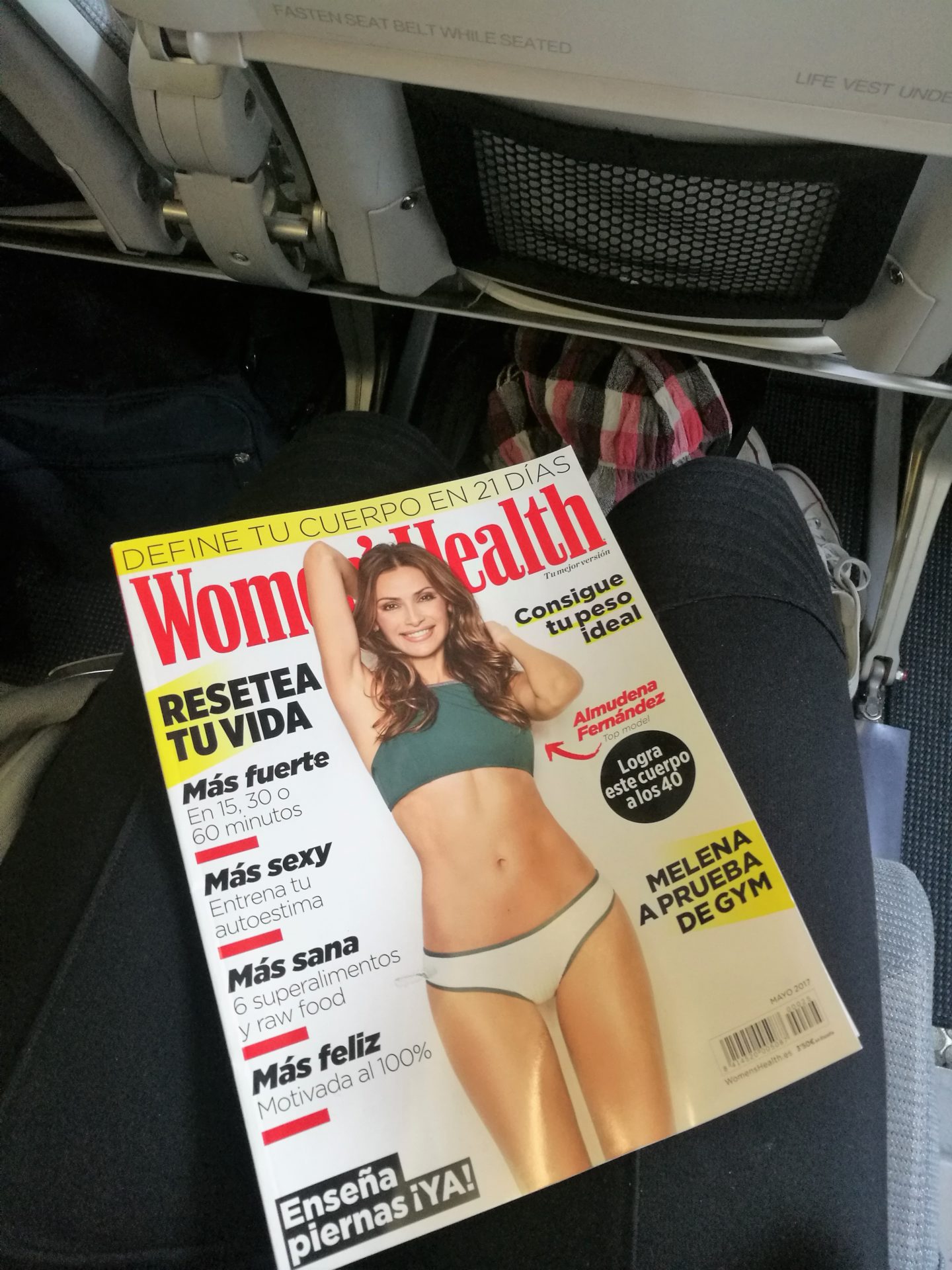 Hasta pronto Madrid Annimarian A girl sitting in a Finnair aiplane reading Spanish Womens' Health