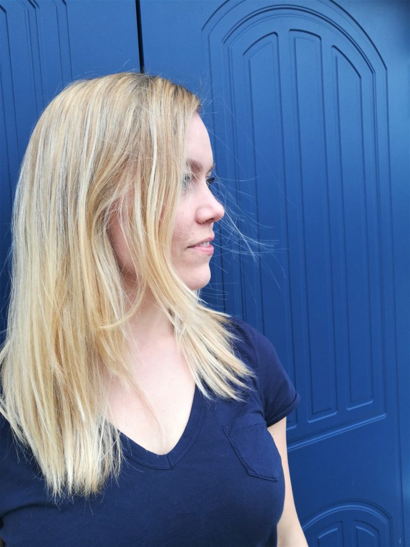 Hair fix Annimarian A blonde Finnish girl standing in front of a blue door