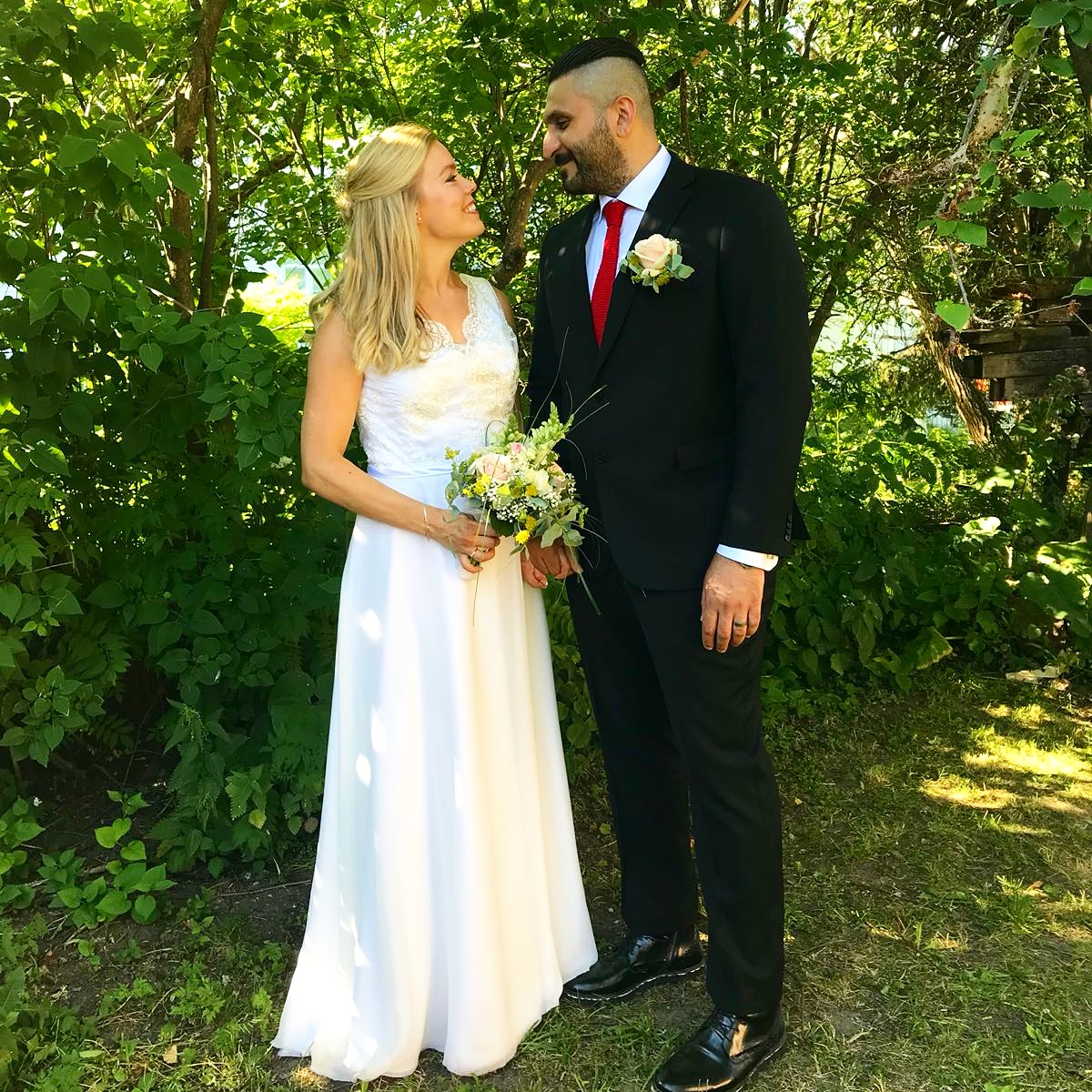 Wedded couple blonde woman in a wedding dress dark man in a suit