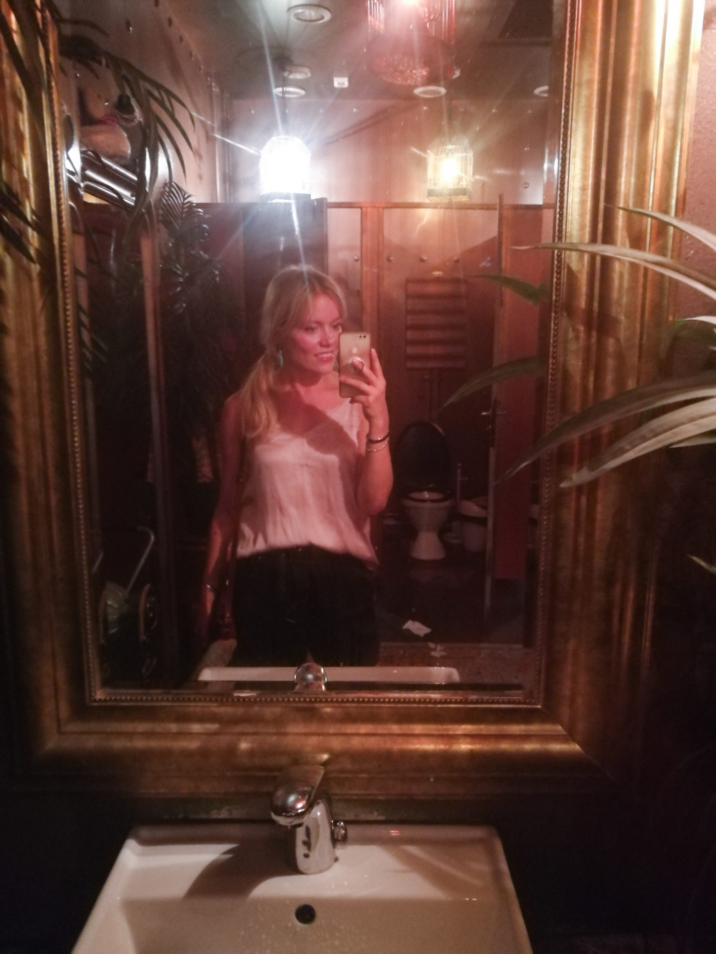 What a weekend A blonde girl taking a mirror selfie in a bar in Helsinki