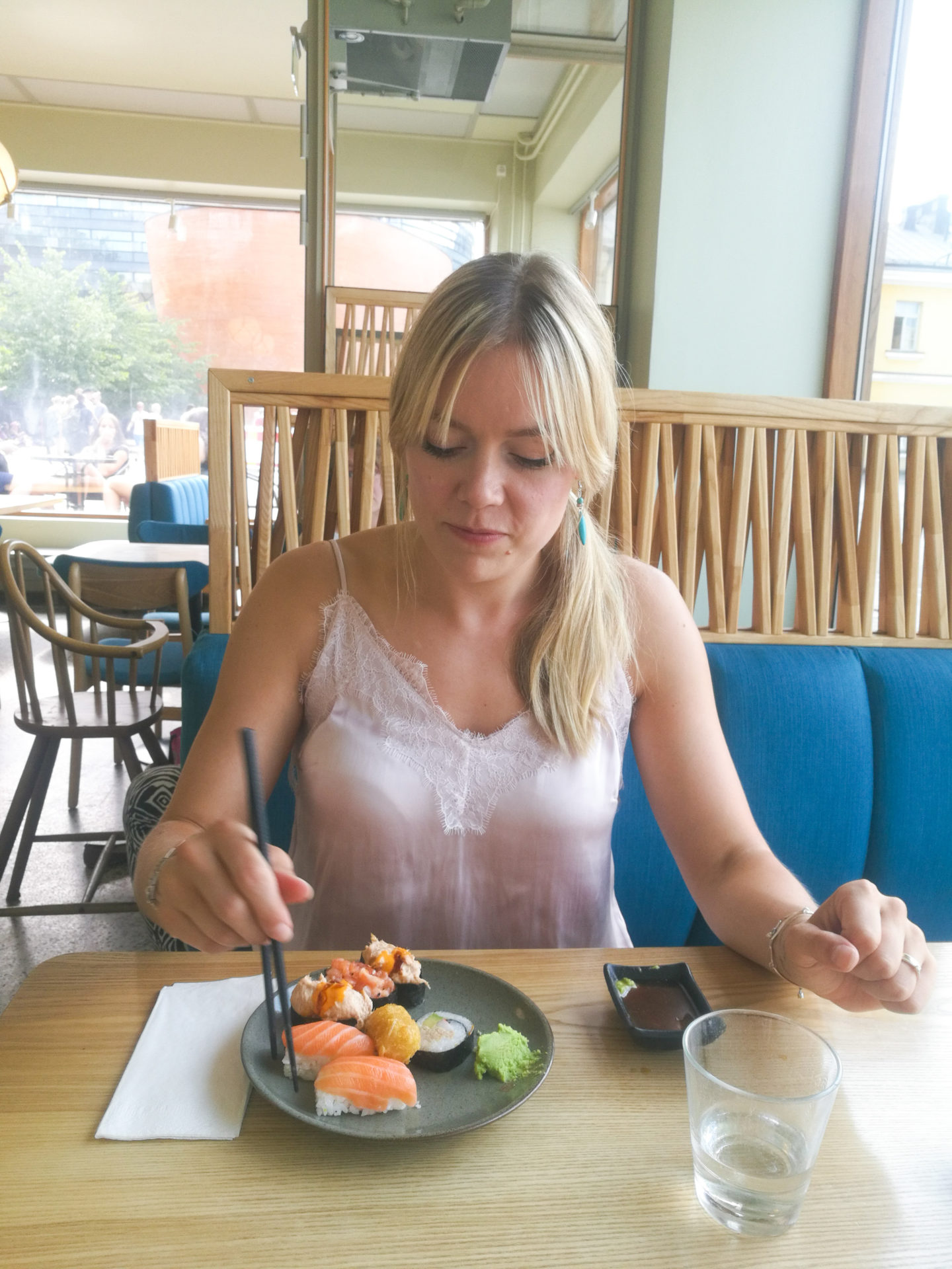 What a weekend A blonde girl eating sushi in a restaurant in Helsinki